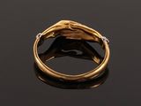 an image of a gold and diamond ring on a black surface