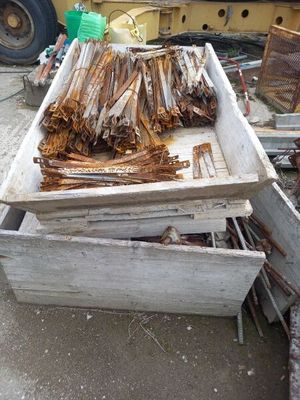 a pile of wood sitting on the ground in front of a truck