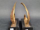 pair of bronze sculptures of a bird on a branch on a black base