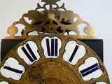 a gold clock with black and white roman numerals on it