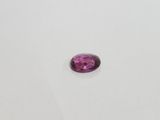 a pink tourmaline stone on a white surface
