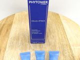 three tubes of phytomer sitting on a wooden table next to a blue box