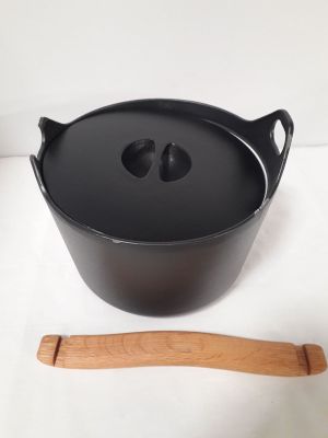 une casserole noire avec une cuillère en bois à côté