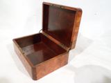 une petite boîte en bois ouverte sur une surface blanche