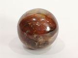 une boule de marbre posée sur une surface blanche, avec un fond blanc
