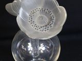 a clear glass vase with a flower on top of it