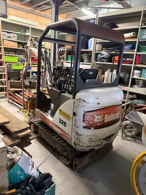 une petite pelleteuse garée dans un garage