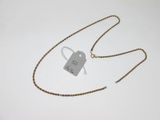 une photo d'un collier muni d'une étiquette, posé sur une surface blanche