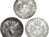 three silver coins with a crown on top of them