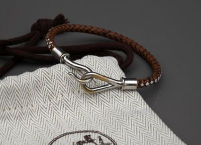 un sac blanc muni d'une corde marron et d'un crochet argenté