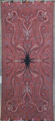 a red and black rug hanging on a wall next to a window