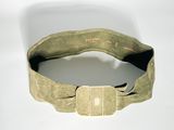 une ceinture munie d'une boucle métallique, posée sur une surface blanche
