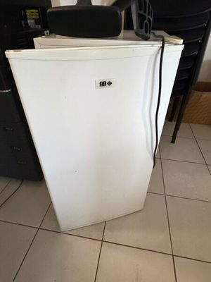 un réfrigérateur blanc placé dans une cuisine à côté d'un réfrigérateur noir
