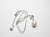 un gros plan d'un collier composé d'une perle montée sur une chaîne