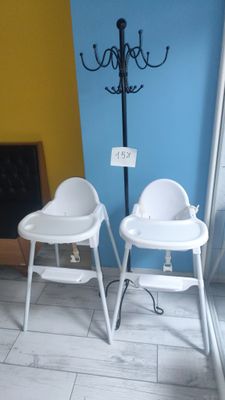 two baby high chairs that are next to each other