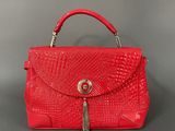 a red handbag with a tassel on the handle