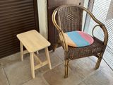 a wicker chair and a stool in front of a door