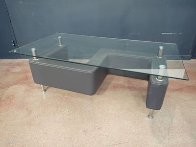 une table en verre sur laquelle se trouve un lavabo, dans une pièce