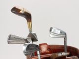 a brown bag with golf clubs in it on a table