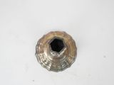 a small metal object on a table with a white background