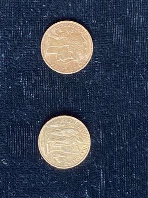 deux pièces d'or posées l'une à côté de l'autre sur une surface noire