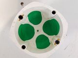 vue du dessous d'un bol vert et blanc posé sur une surface blanche