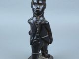 statue d'un homme coiffé d'un chapeau et tenant un pistolet
