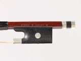 a violin bow and a bow rest on a white surface