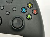a close up of a video game controller on a white surface