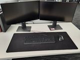 two computer monitors and a keyboard on a desk