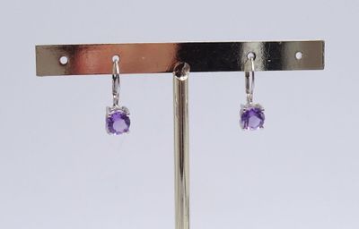 pair of amethorate and diamond earrings on a metal stand