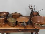 de nombreuses casseroles et poêles posées sur une table en bois