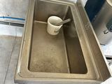 a sink with a spoon in it and a trash can
