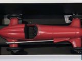 a red toy car in a black box on display