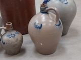 three vases sitting on the floor next to a pot