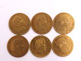 six gold sovereigns of different sizes and shapes