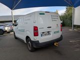a white van parked in a parking lot under a blue umbrella