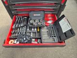 une boîte à outils contenant des outils, posée sur le sol