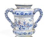 a blue and white vase with a handle on a stand