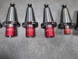 six different types of drill heads are lined up on a metal surface