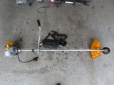 a yellow and black pole saw next to a black bag and a yellow and black umbrella