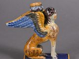 figurine of a winged dog with a hat on its head