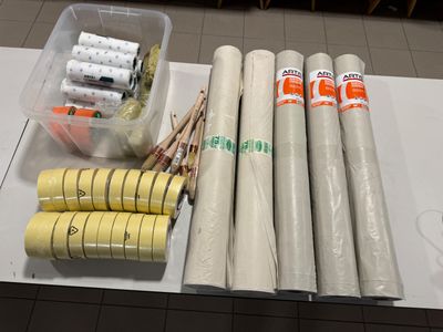 plusieurs rouleaux de ruban adhésif posés sur une table, à côté d'un pot de colle