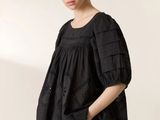 the woman is wearing a black dress and a black jacket
