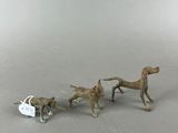 three figurines of dogs and a cat on a table