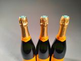 three bottles of champagne sitting next to each other on a table