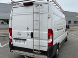 a white van parked in a parking lot with a ladder on the back of the van