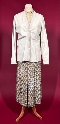 a white jacket and skirt on a mannequin stand
