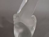 a clear glass sculpture of a bird on a table