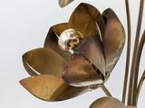 a metal sculpture of a flower with a gold ring on it